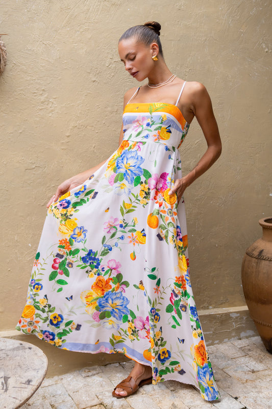 woman posing in an orange floral maxi dress