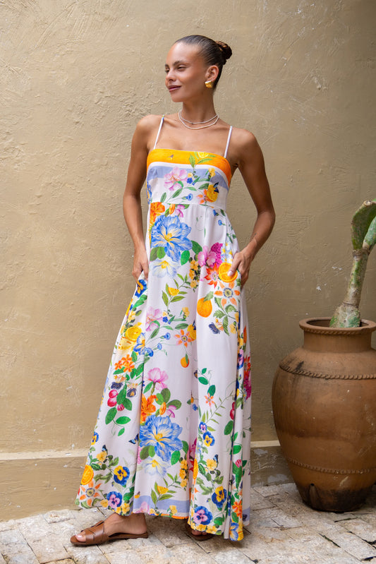 woman posing in an orange floral maxi dress