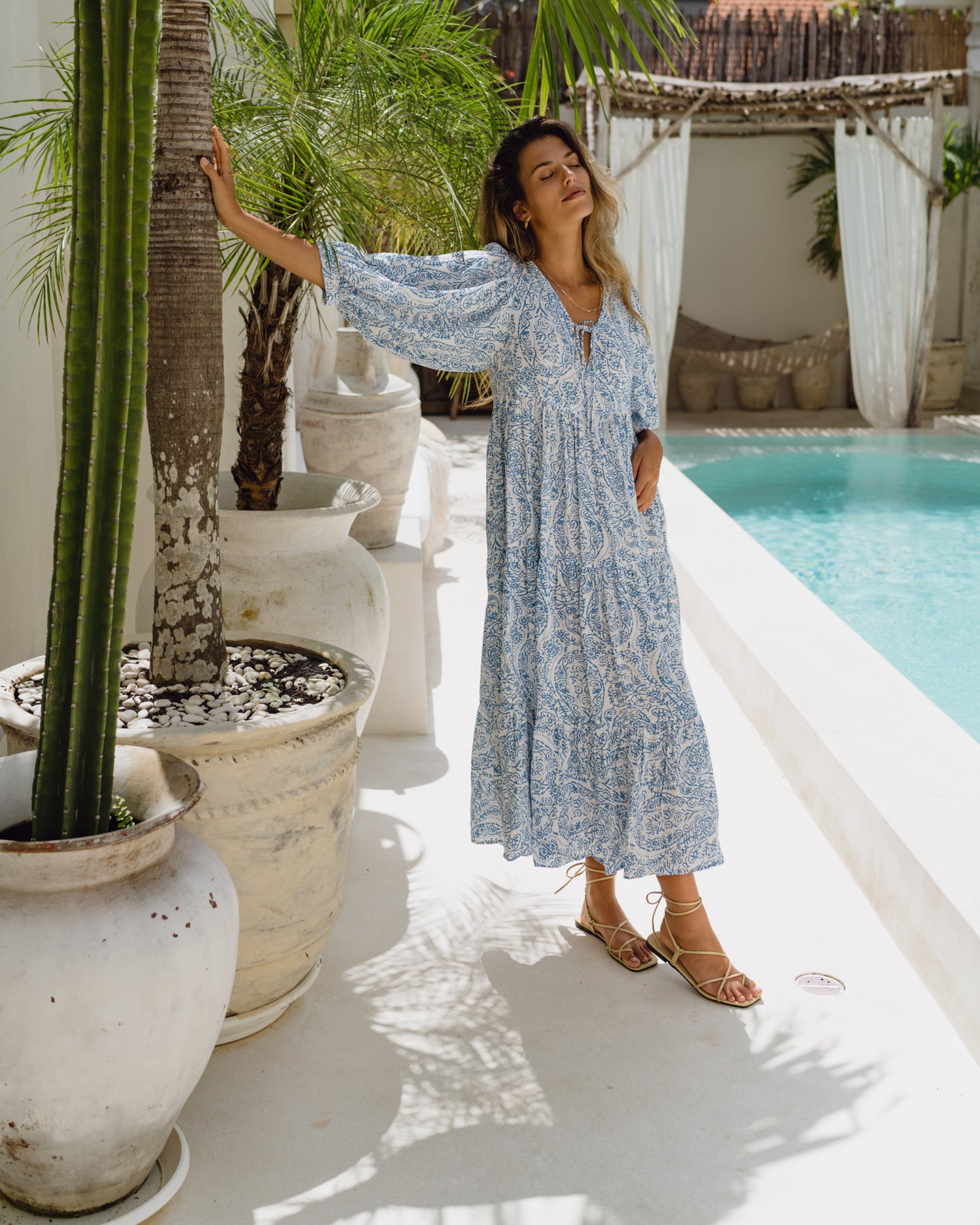 woman wearing a blue boho dress standing in relaxed pose